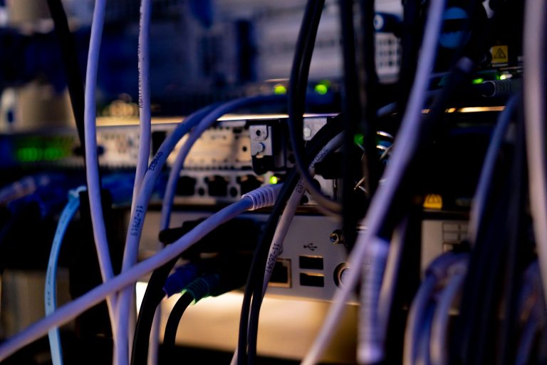 a bunch of patch network cables sorted in a rack cabinet leading from a patch panel in a server rack