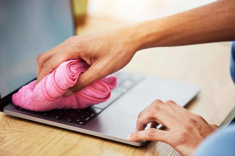 Hands, wipe and laptop with dust, cleaning and hygiene with a cloth, washing or bacteria. Pc, perso